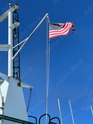 American flag waving on a ship with a blue sky in the background