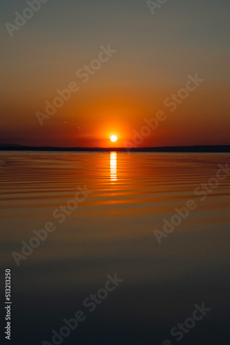 Sunset over the lake. Sunset or sunrise background photo.