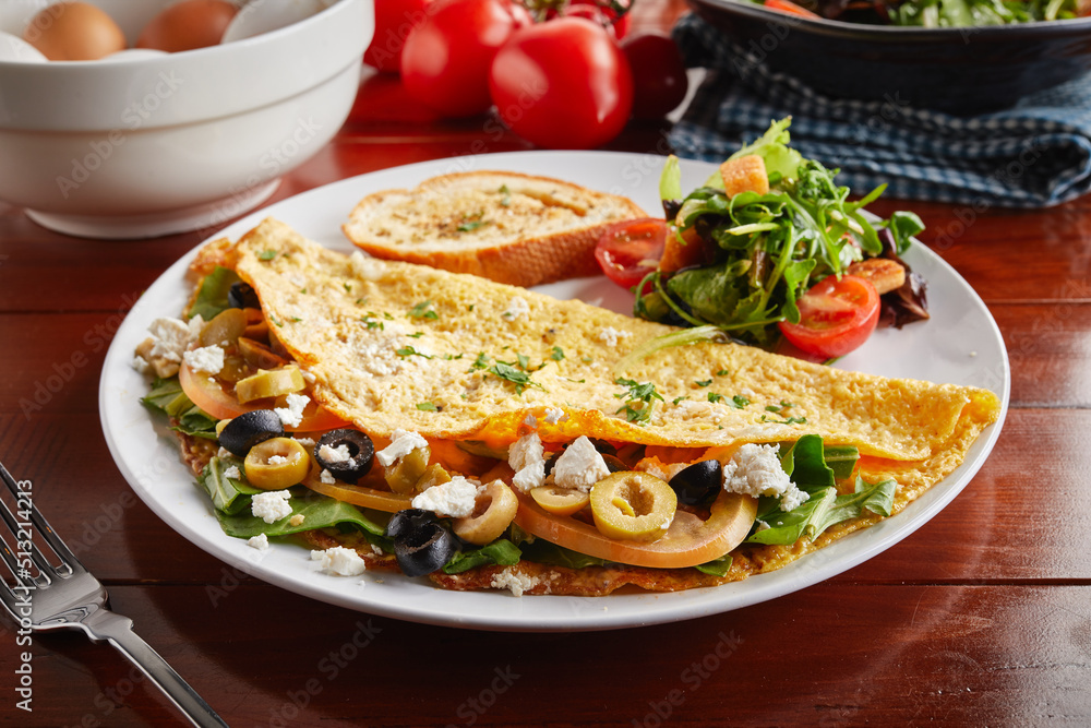Mediterranean omelette roll with salad served in a dish isolated on wooden background side view Mediterranean omelette roll with salad served in a dish isolated on wooden background side view