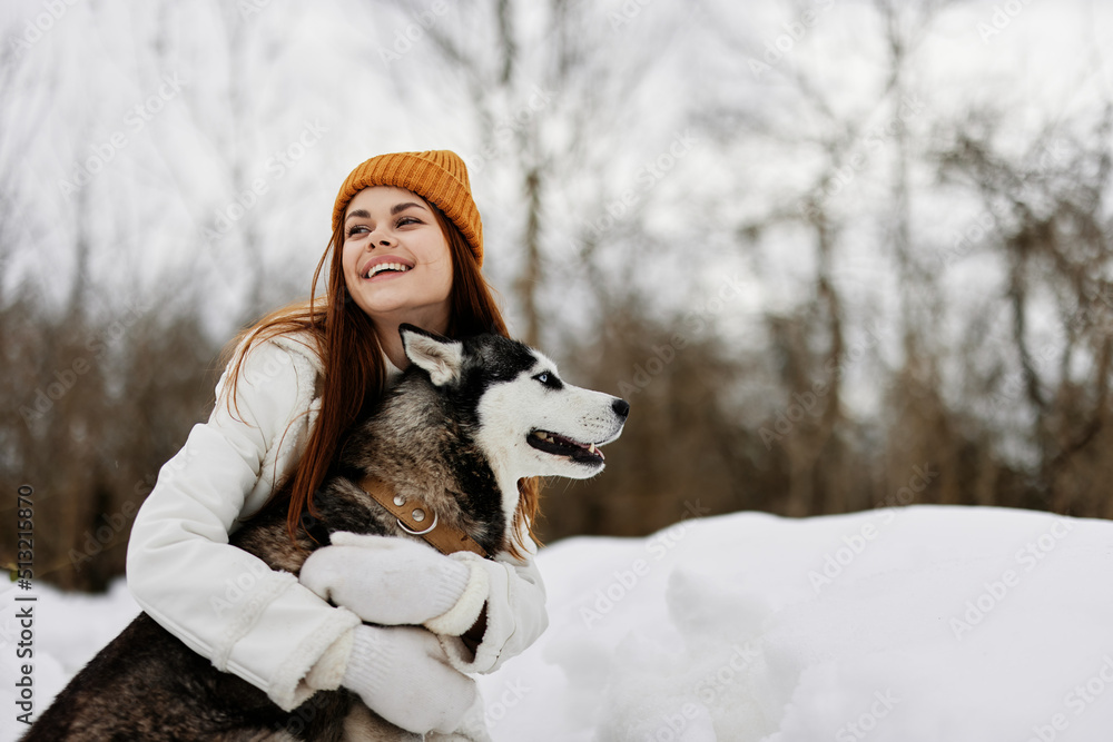 woman in the snow playing with a dog fun friendship fresh air - obrazy, fototapety, plakaty 