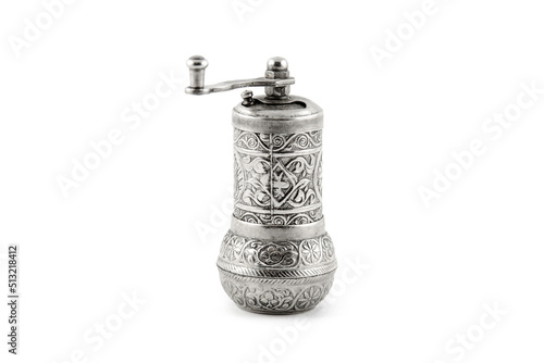 Antique silver metal pepper mill with arabic pattern on white backround