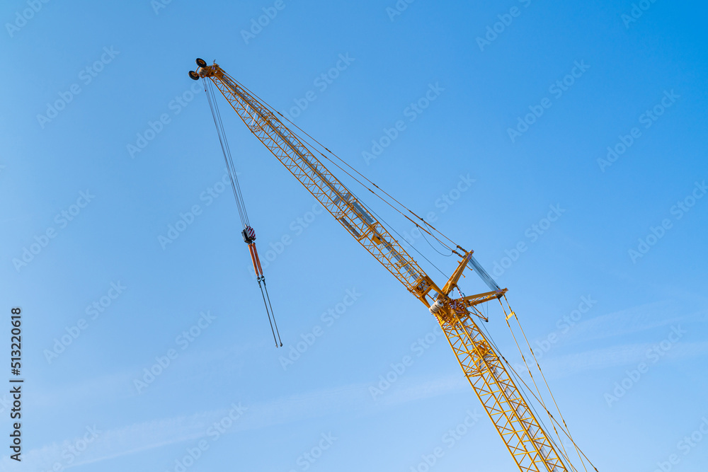 Yellow crane boom against the blue sky. Yellow crane boom against the blue sky.