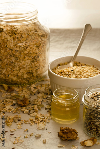 Granola ingredients in bowls and jars, cereal, honey, nuts and seeds 