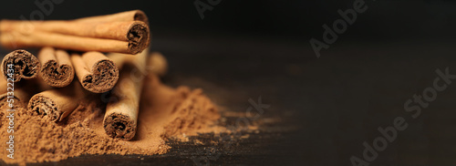 Photo Aromatic cinnamon sticks and powder on table, closeup view with space for text