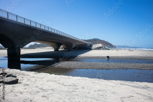 Torrey Pines State Beach, California, with people exploring the Surf and Sand with the mouth of the San Dieguito River Bridge photo