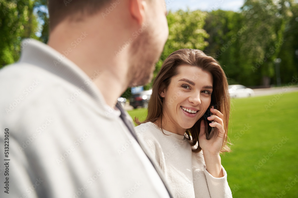 Happy woman talking on mobile phone during date outdoors Happy woman talking on mobile phone during date outdoors