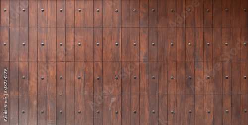 panoramic texture of a mistreated varnished wood wooden fence surface with metal rivets pattern photo