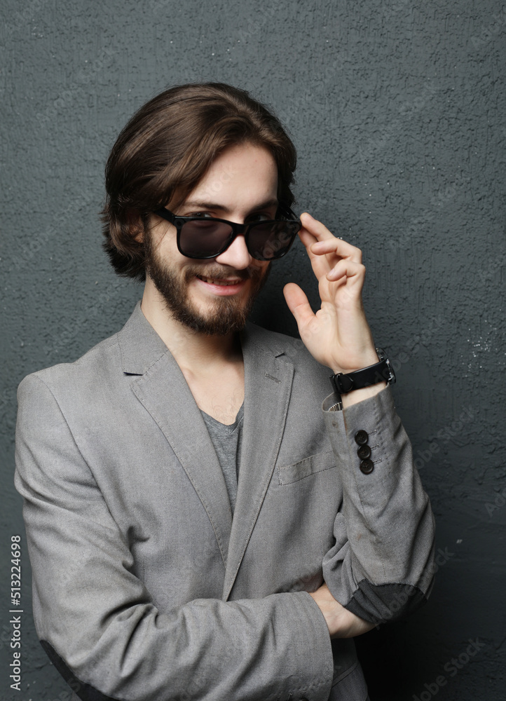 Portrait of a young handsome man wearing sunglasses on grey background Portrait of a young handsome man wearing sunglasses on grey background
