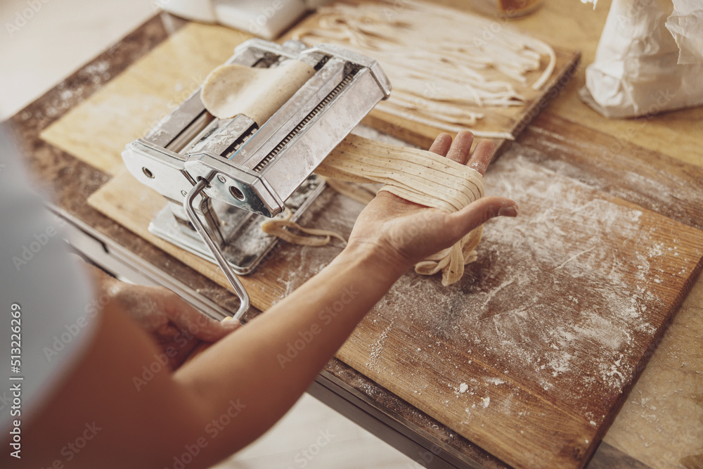 Noodle slicing process using homemade noodle cutter. Italian traditions