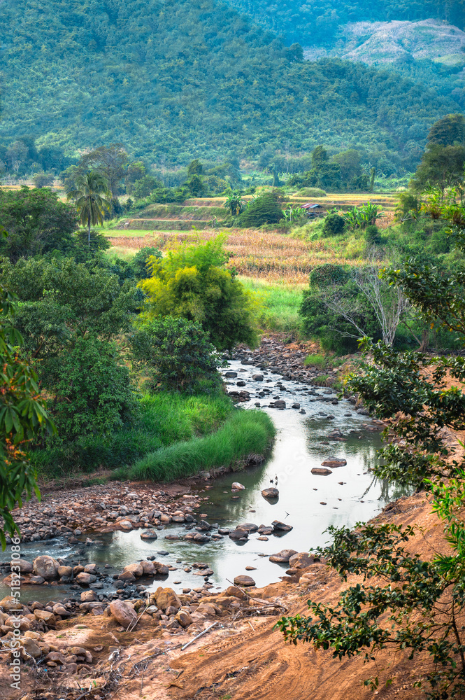 A photograph of a rural landscape in Thailand with mountains, rivers, streams and rice fields. A photograph of a rural landscape in Thailand with mountains, rivers, streams and rice fields.