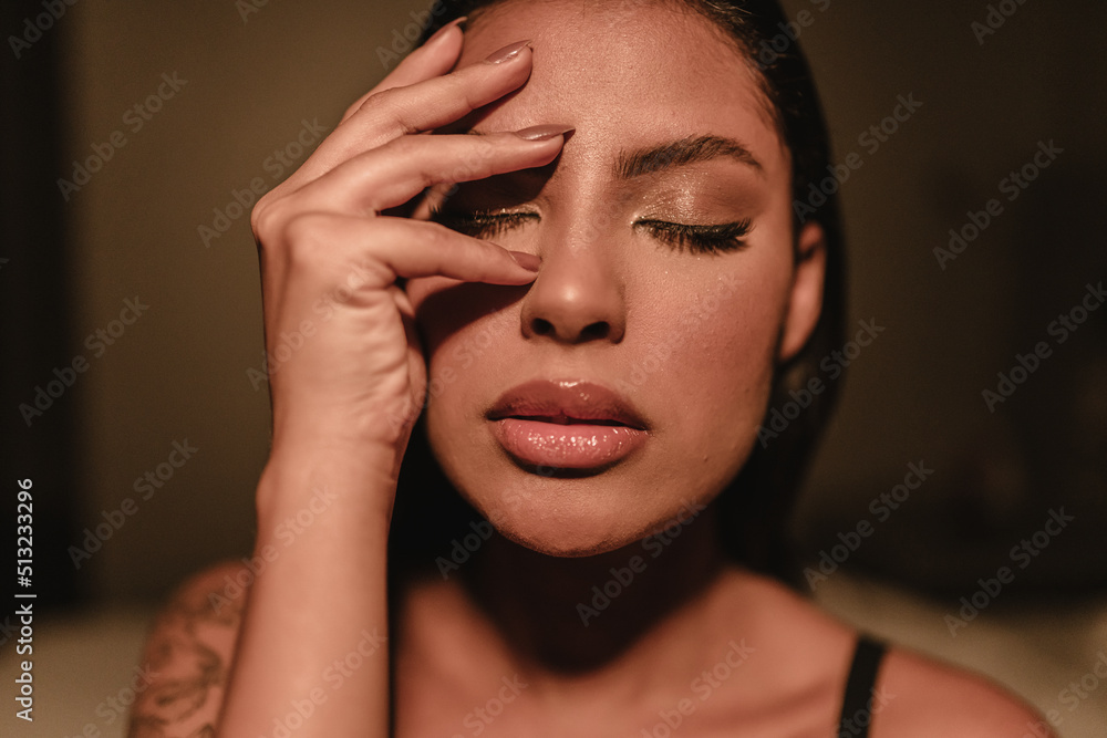 Emotional portrait of a beautiful Latin girl cover her face with hand indoors. Emotional portrait of a beautiful Latin girl cover her face with hand indoors.