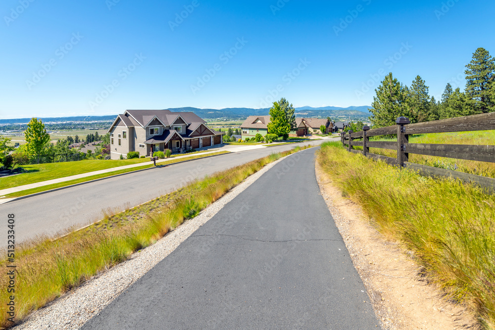 A walking trail along a hillside subdivision of homes with a view overlooking the Spokane Valley, Washington area.