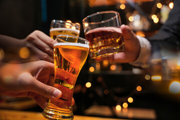 food and drink male friends are happy drinking beer and clinking glasses at a bar or pub.