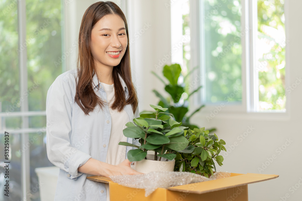 Happy asian young woman, customer received, unpack package carton open parcel in cardboard box, holding ceramic plant pot. Moving, preparing in new house, relocation. Online shop delivery at home. Happy asian young woman, customer received, unpack package carton open parcel in cardboard box, holding ceramic plant pot. Moving, preparing in new house, relocation. Online shop delivery at home.