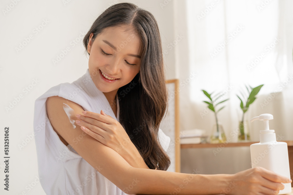 Healthy skin care, beauty asian young woman in bathrobe, towel after shower bath at home, hand in applying, putting moisturizer on her arm. Skin body cream moisturizing lotion, routine in the morning Healthy skin care, beauty asian young woman in bathrobe, towel after shower bath at home, hand in applying, putting moisturizer on her arm. Skin body cream moisturizing lotion, routine in the morning