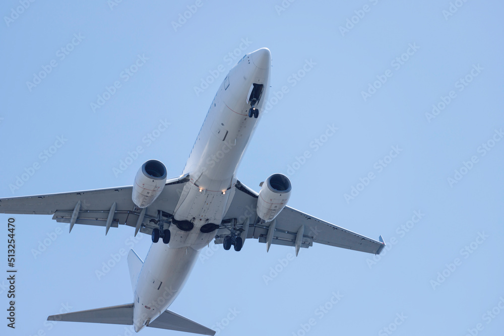 青空を背景に羽田空港に着陸態勢に入る飛行機