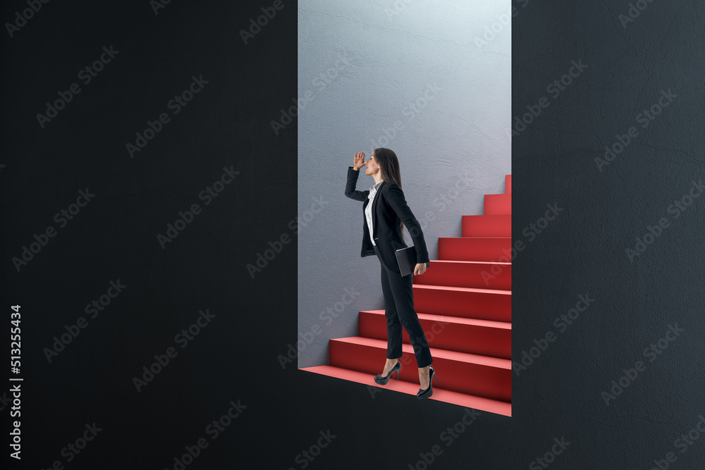 Obraz premium Attractive thoughtful young european businesswoman standing and looking into the distance in abstract concrete wall opening with red stairs and mock up place. Door, opportunity and success concept.