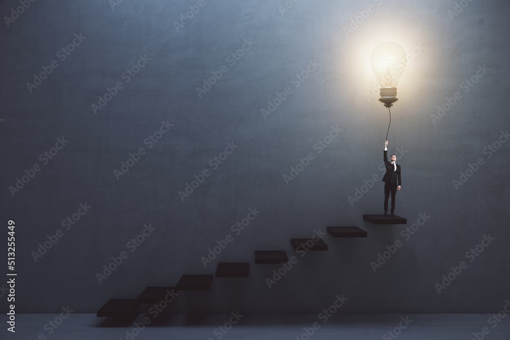Creative and idea concept with front view on man in suit on the top of stairway turning on big light bulb on dark concrete background in empty hall Creative and idea concept with front view on man in suit on the top of stairway turning on big light bulb on dark concrete background in empty hall
