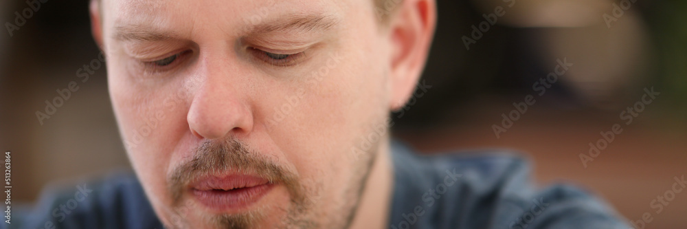 Sad and overwhelmed with something bearded middle aged person looking down Sad and overwhelmed with something bearded middle aged person looking down