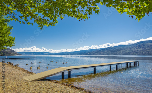 Wooden dock on a calm lake on beautiful summer morning  Okanagan Lake  Canada. Summer vacation in Canada