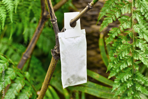 Sachet with beneficial predatory mites used for pest control attached to plant