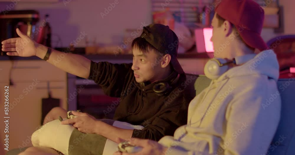 Emotional discussion of the gameplay by the guys in the room. They use gestures to prove a point. One guy was upset, the second one rejoices, the contrast of the mood. Emotional discussion of the gameplay by the guys in the room. They use gestures to prove a point. One guy was upset, the second one rejoices, the contrast of the mood.