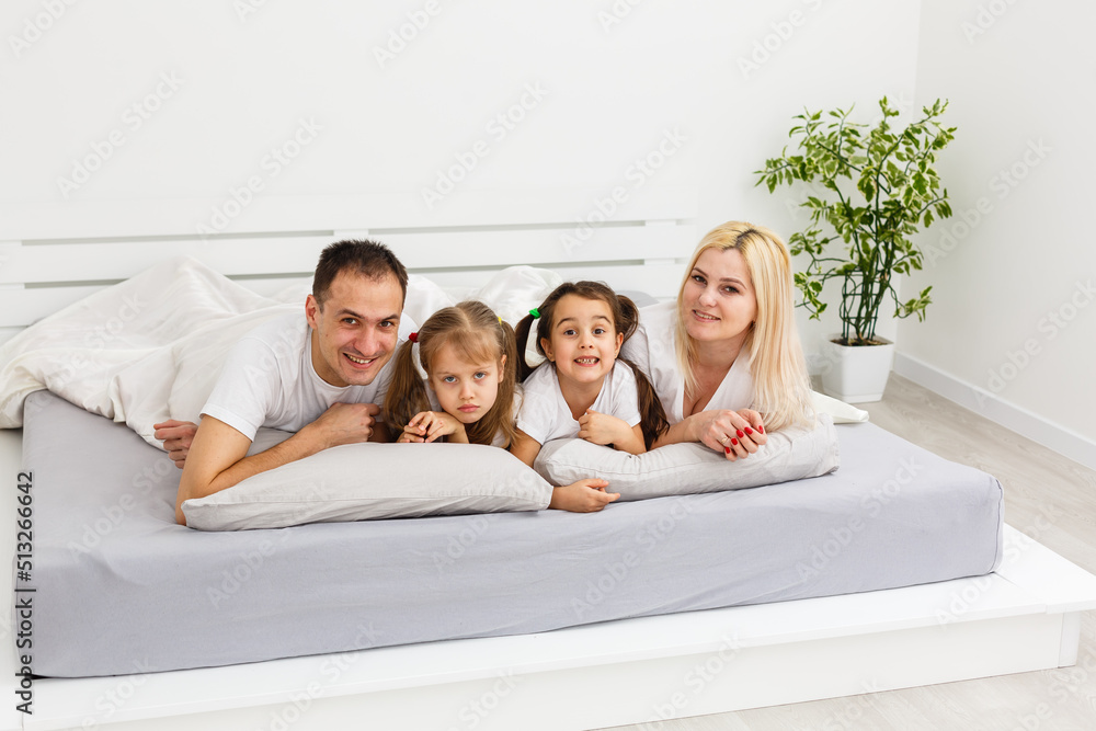 Young family resting together in parent's bed Young family resting together in parent's bed