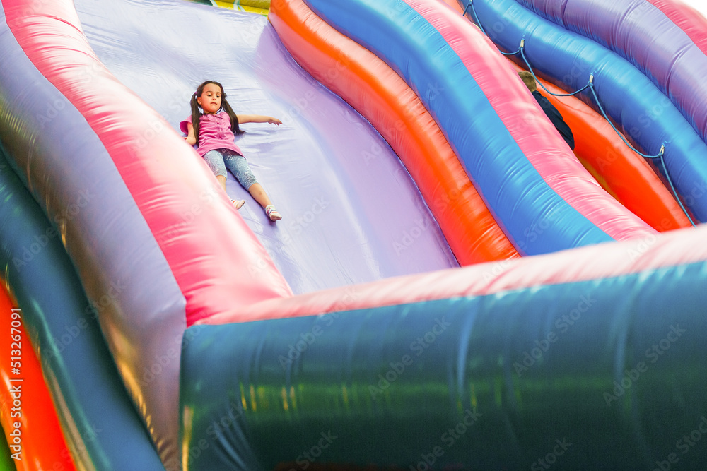 A cheerful child plays in an inflatable castle