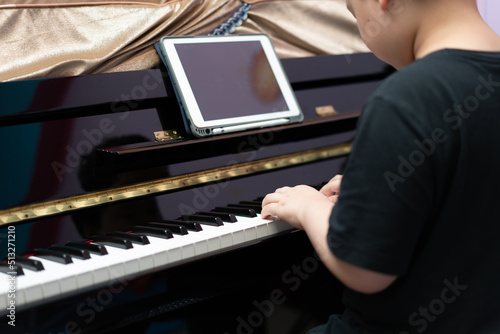 boy play piano with online learning © vachcameraman