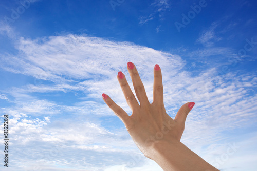 Woman hand riseing to sky reaching for hope.