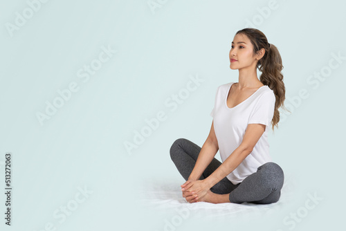 Woman sitting on the floor doing stretches or yoga for healthy concept.