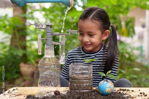 Blurred of little girl is learning science experiment at home and planting with recycle plastic bottle, concept of STEM, education, montessori, nature, environment, weather, climate change for kid. photo