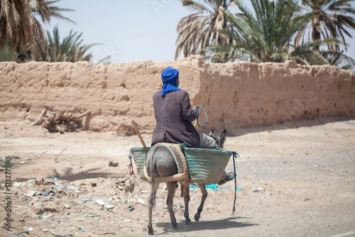 Hombre subido en burro con alforjas. Estampa costumbrista en el sur de Marruecos. photo