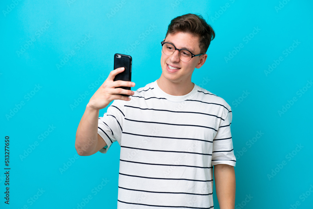 Young handsome Brazilian man isolated on blue background making a selfie Young handsome Brazilian man isolated on blue background making a selfie