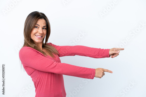 Middle age caucasian woman isolated on white background pointing finger to the side and presenting a product