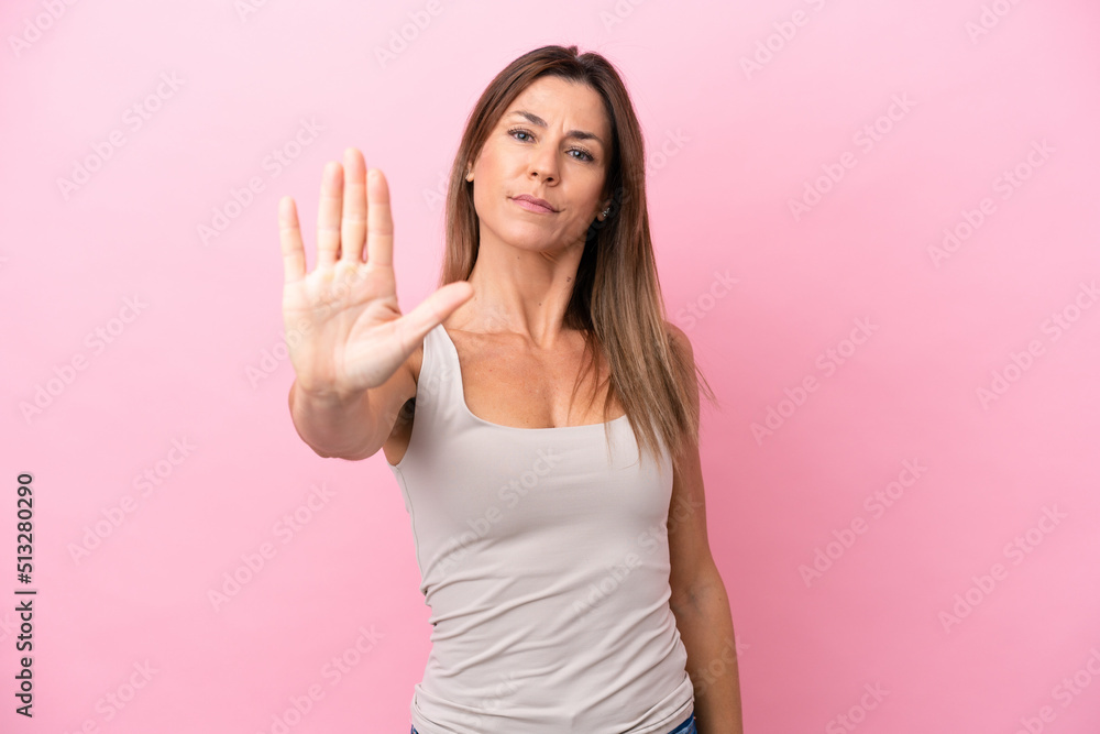 Middle age caucasian woman isolated on pink background making stop gesture Middle age caucasian woman isolated on pink background making stop gesture