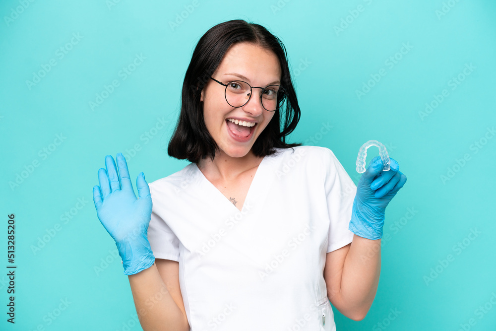 Young caucasian woman holding envisaging isolated on blue background saluting with hand with happy expression Young caucasian woman holding envisaging isolated on blue background saluting with hand with happy expression