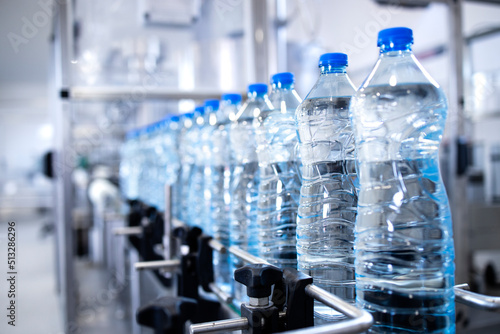 Fotografija Plastic bottles on conveyor belt being filled with drinking water
