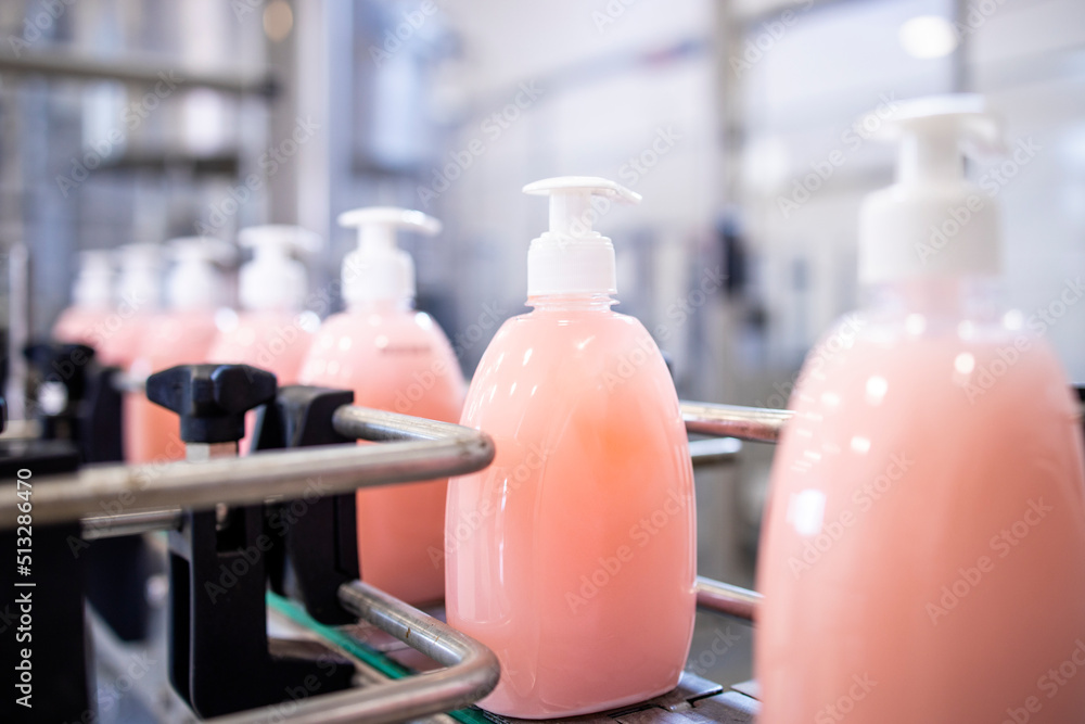 Bottled liquid soap being produced in factory. - obrazy, fototapety, plakaty 