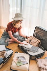 Travel. Staycation.local travel new normal.Girl packing luggage in suitcase and travel documents Travel,tourism,vacation,relocation.Mental health and travel vacation Film grain