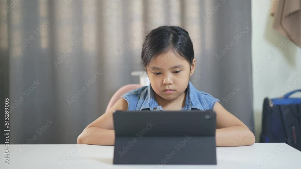 Asian child happy smile talking fun to teacher via video call learning on computer tablet or kid girl student enjoy speaking studying on study online class or person learn from home school by internet Asian child happy smile talking fun to teacher via video call learning on computer tablet or kid girl student enjoy speaking studying on study online class or person learn from home school by internet