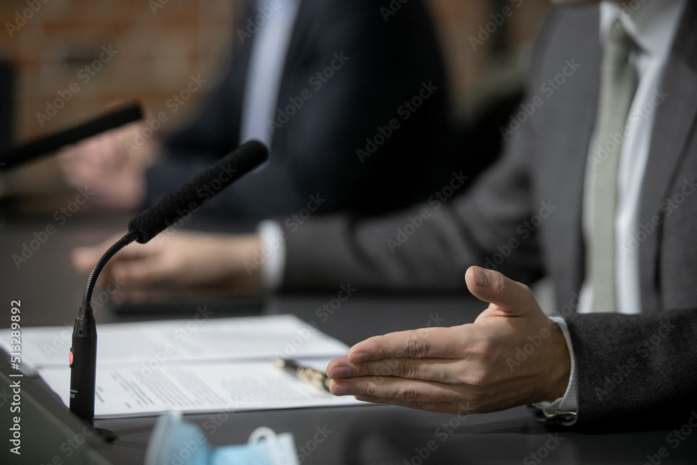 Obraz premium Close Up Executive Lawyer or JUDGE HAND Striking the GAVEL on Sounding Block in LAW OFFICE, JUSTICE and LAW Concept Background, Businessmen in Suits sitting on the table Next to a ็ammer.
