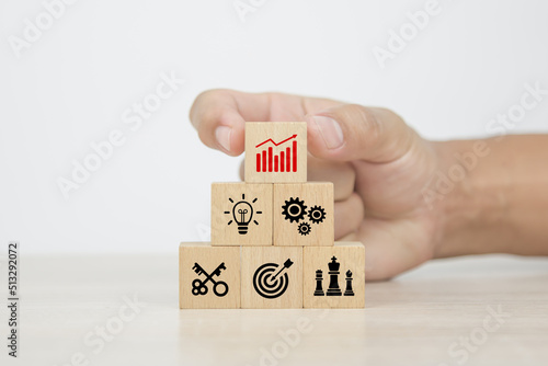 Hand choose cube wooden blocks stack with graph icon on business strategic plan concept of financial research for management to success and growth and strategy planning.