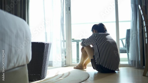 Sad woman sitting on the floor alone in the bedroom. family violence Family problems, stress, violence, depression and suicide concepts, remote vision.
