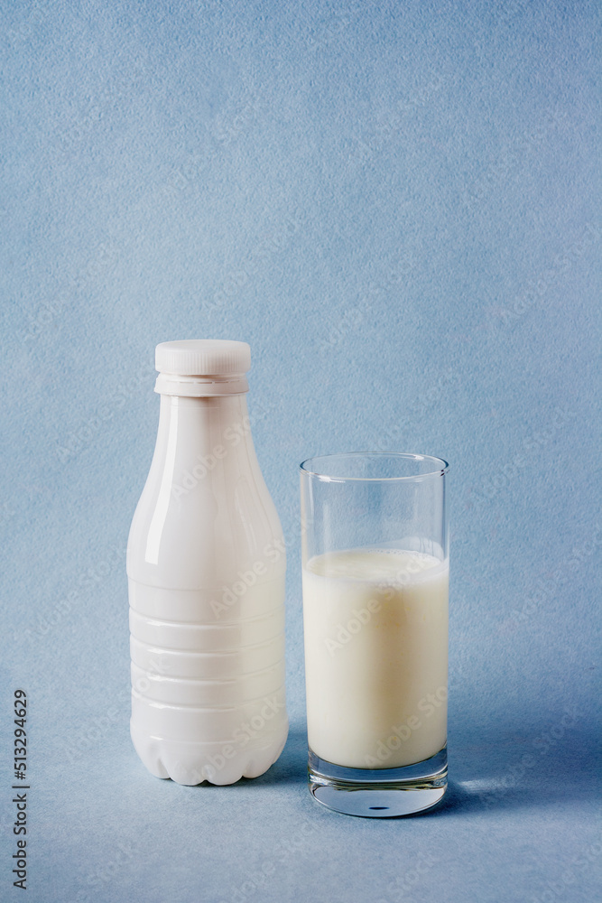 a bottle and a glass of yogurt on a blue background, a copy of the space a bottle and a glass of yogurt on a blue background, a copy of the space