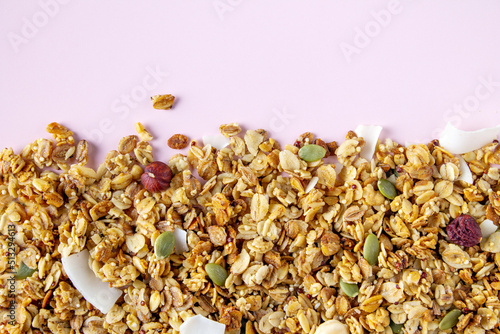 granola made of oat flakes, hazelnuts, pumpkin seeds, coconut chips, dried berries, close-up