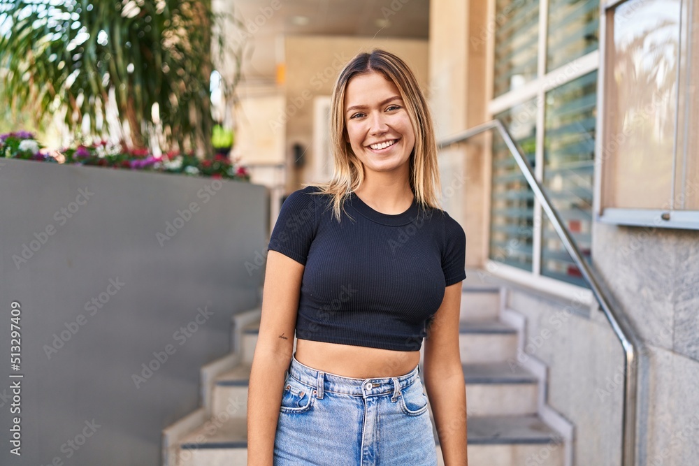Young hispanic woman smiling confident standing at street