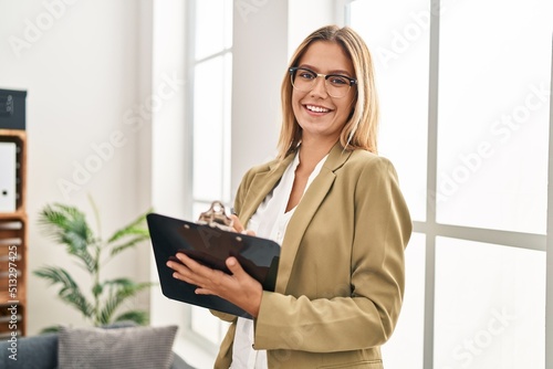 Canvas Print Young hispanic woman psychologist writing mental report standing at psychology c