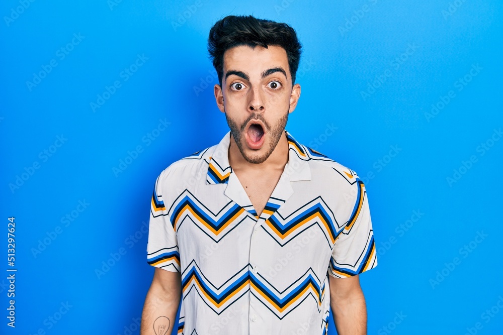 Young hispanic man wearing casual clothes afraid and shocked with surprise and amazed expression, fear and excited face.