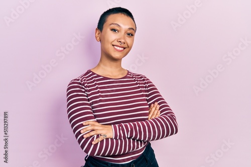 Beautiful hispanic woman with short hair wearing casual striped sweater happy face smiling with crossed arms looking at the camera. positive person.